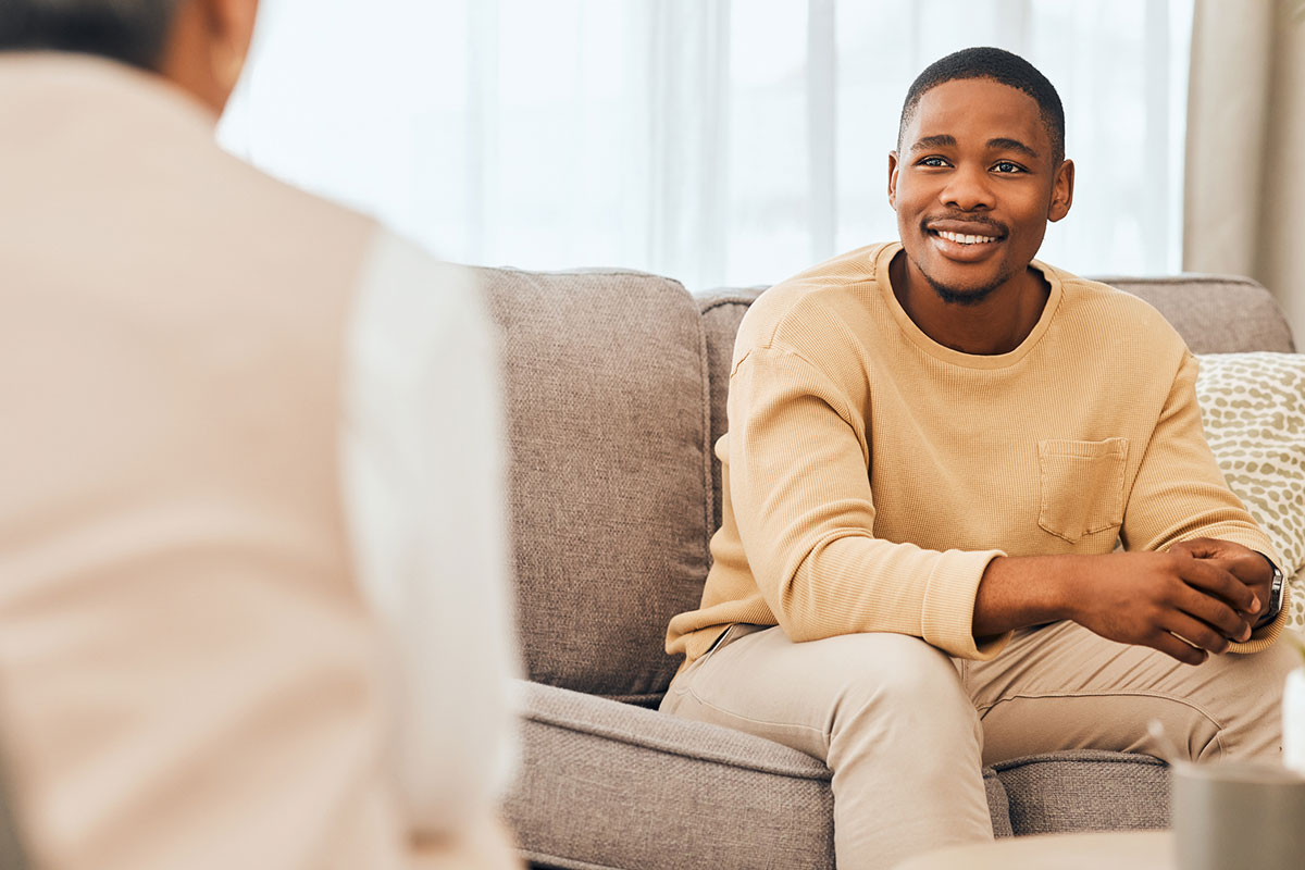 Black man, counseling and psychology consulting for therapy, mental healthcare or support. Happy patient talking to psychologist, therapist and medical help in consultation, advice and wellness check