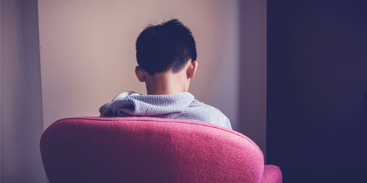 depressed boy sitting alone