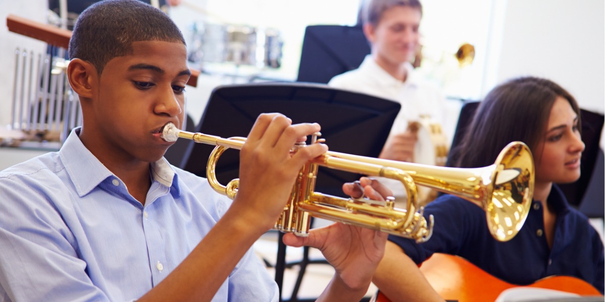 teen boy plays trumpet