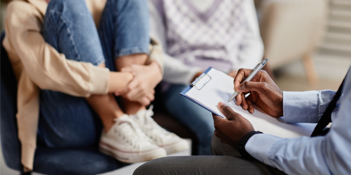 teen sitting with parent and therapist