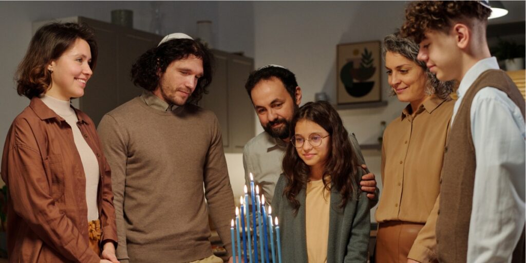 family with teens practicing holiday ritual lighting candles