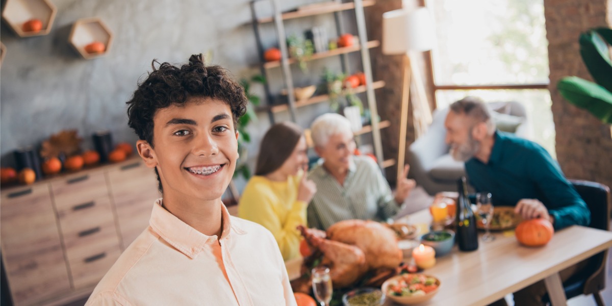 teen smiling in front of thanksgiving table