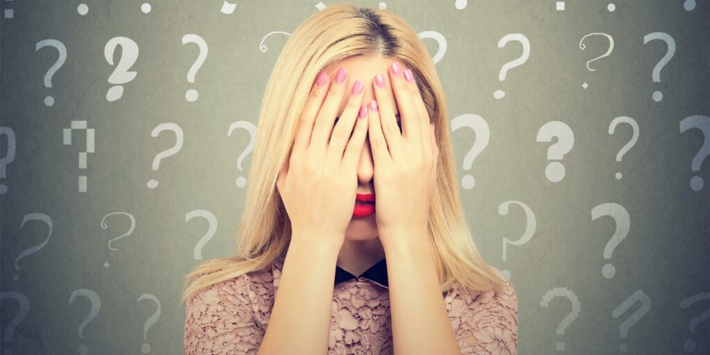 woman covering face with questions about adhd