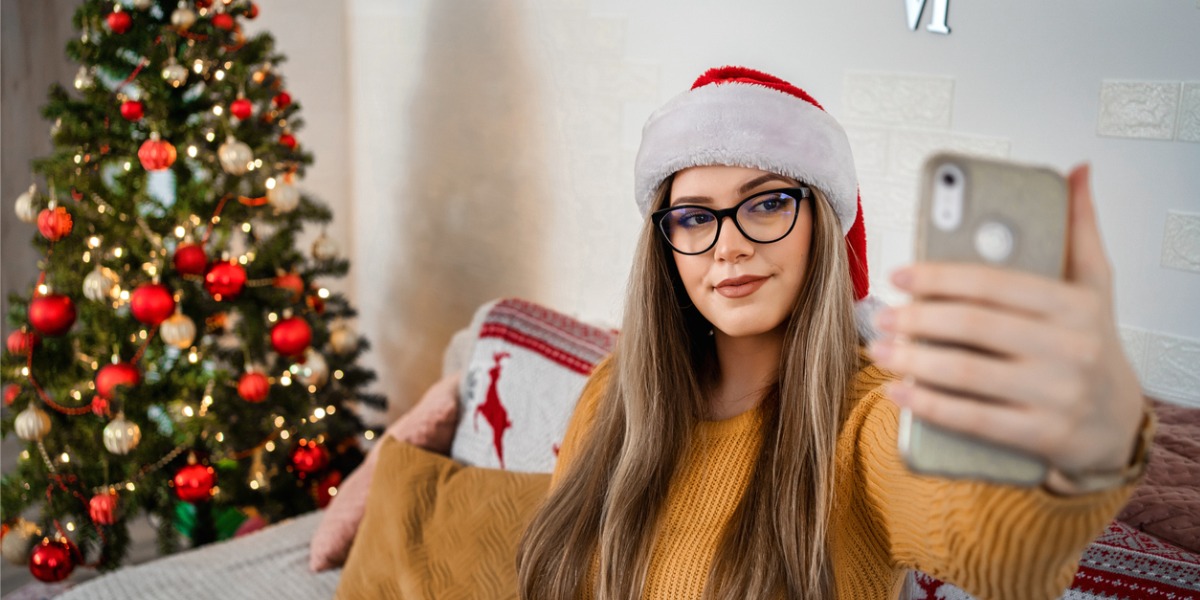 gen z woman taking selfie by a christmas tree