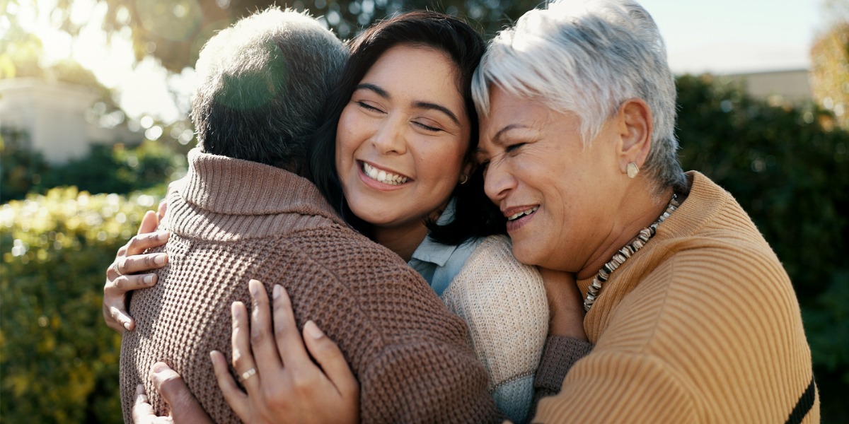 parents hugging a young adult child