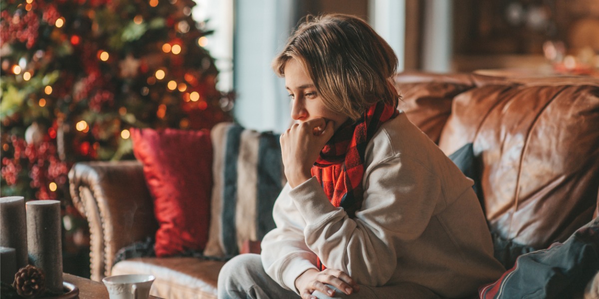 teen boy depressed by christmas tree