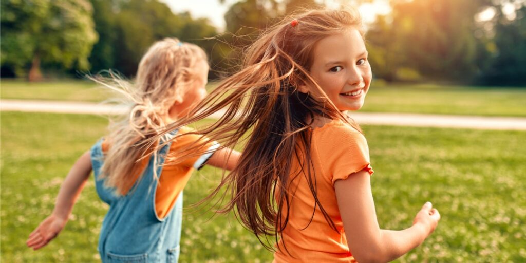 two young children running and smiling