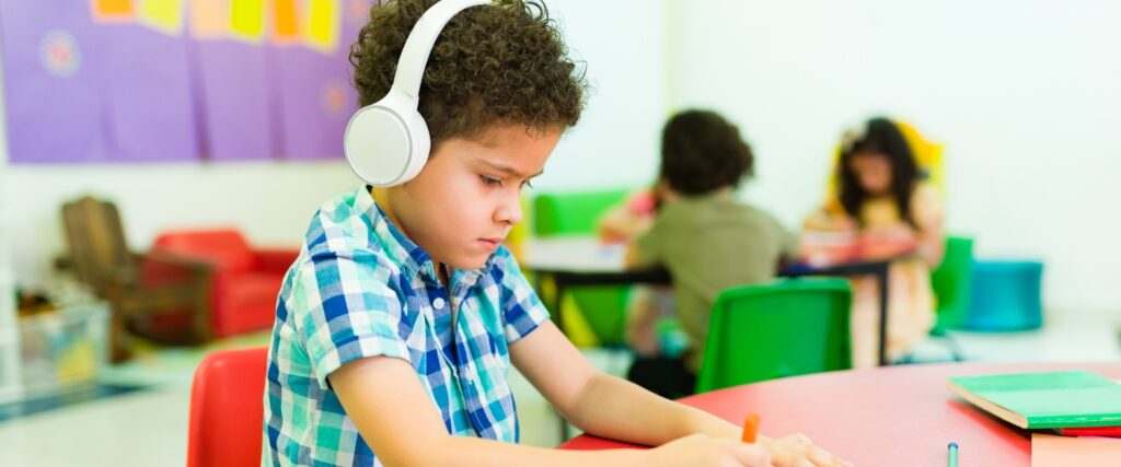 young boy wearing headphones in classroom