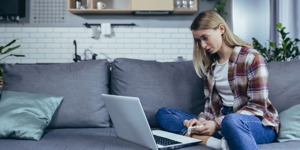 young woman doing telehealth on her laptop