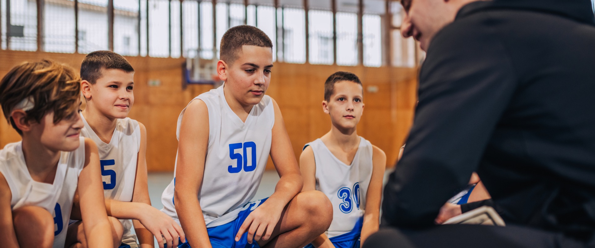 youth in sports group talking with coach