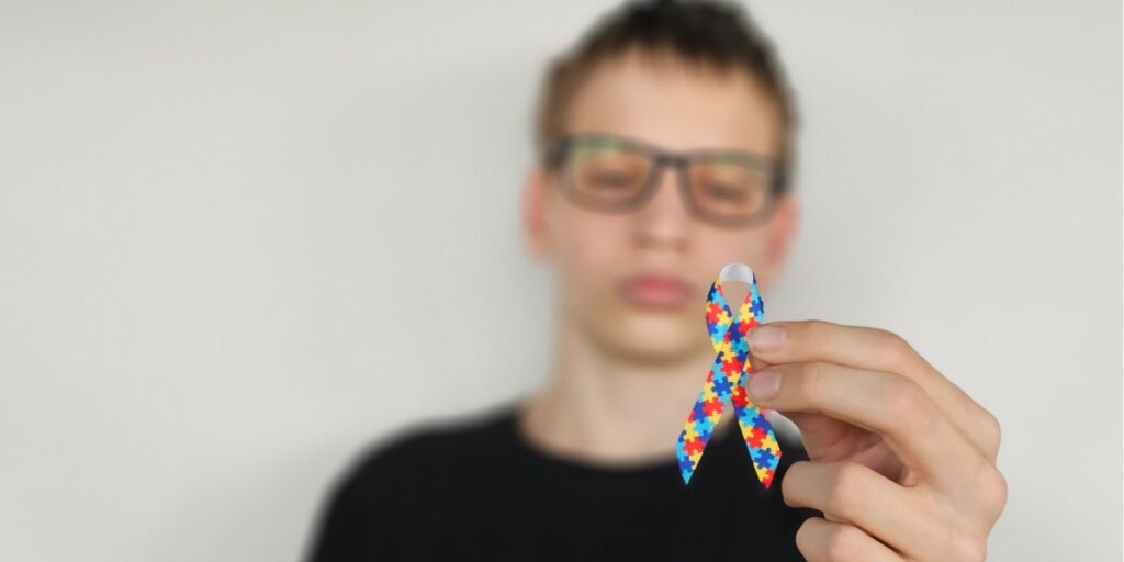 boy holding autism awareness ribbon