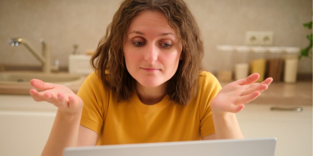 woman baffled looking at laptop