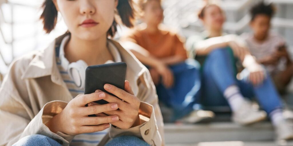 teen girl on smart phone at school