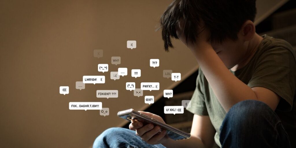 child overwhelmed looking at social media messages on his phone