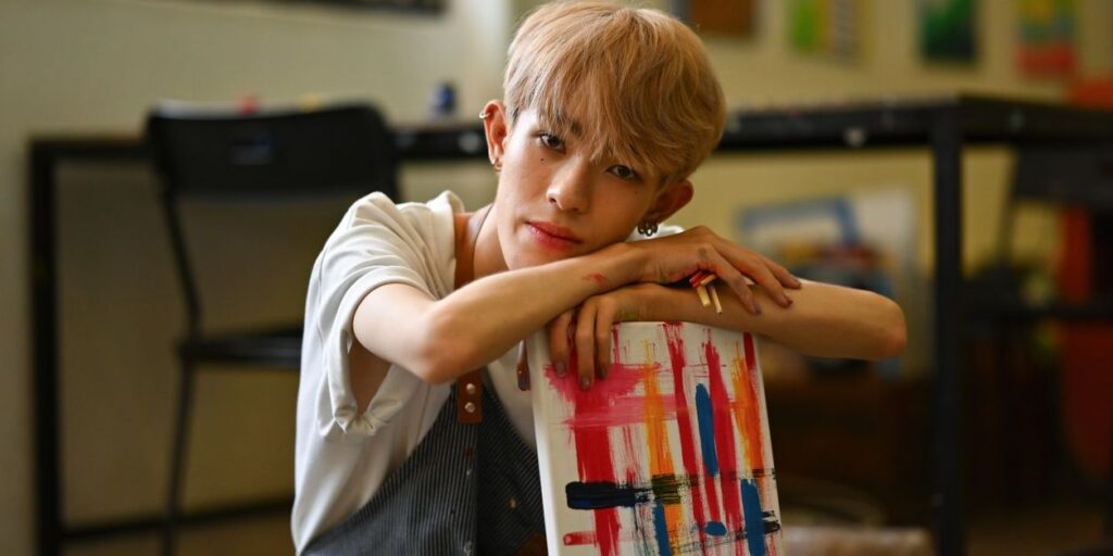 teen holding a painting he's created